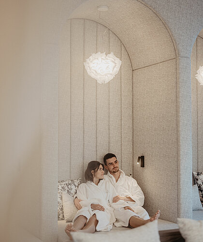 Paar entspannt im stilvollen Ruheraum Wolkennest des Hotel Berghof in Salzburg.