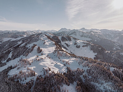 Winterliche Berglandschaft mit verschneiten Hängen und Wäldern nahe dem Hotel Berghof
