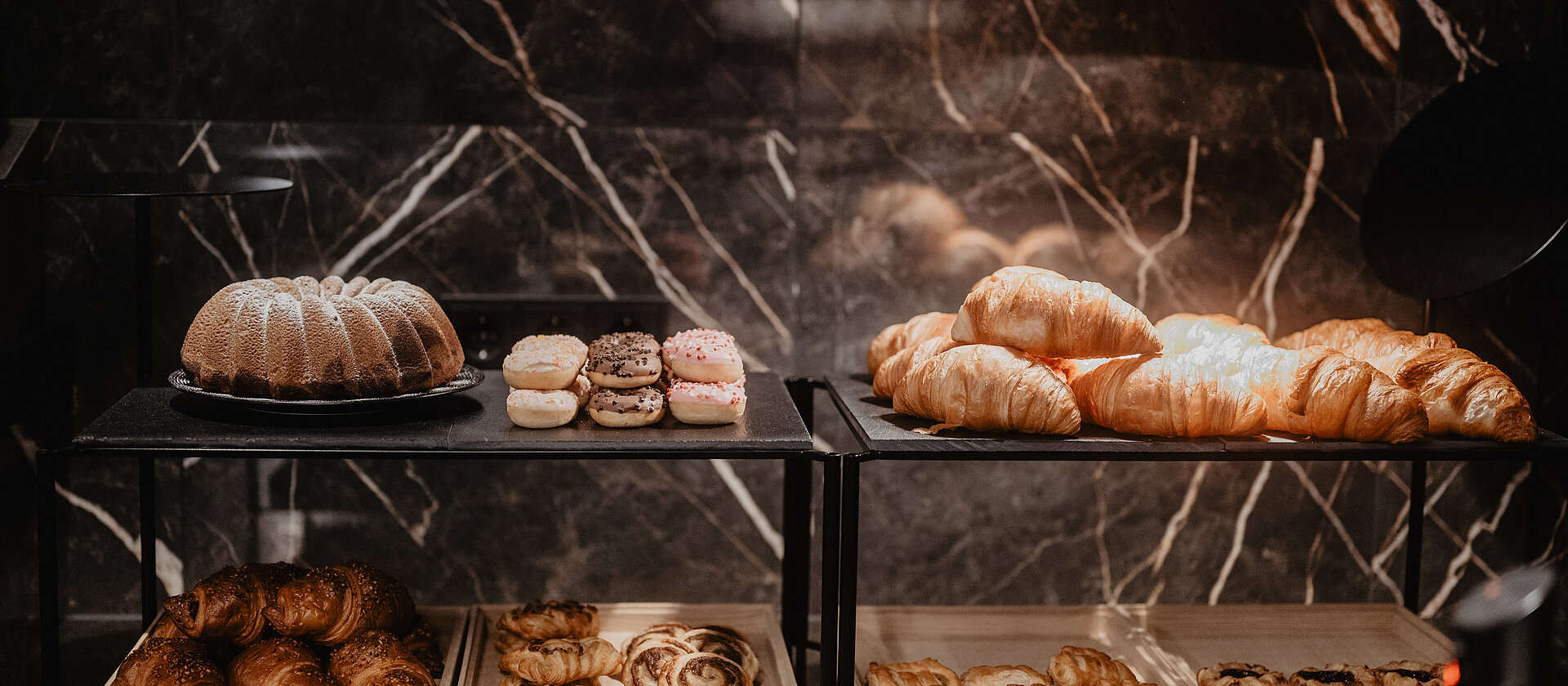 Vielfalt an Croissants, Donuts und Kuchen auf dem Frühstücksbuffet im Hotel Berghof in Salzburg.