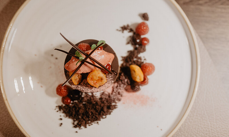 Feines Schokoladendessert mit Beeren und kunstvoller Garnitur im Hotel Berghof in Österreich.