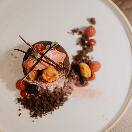 Feines Schokoladendessert mit Beeren und kunstvoller Garnitur im Hotel Berghof in Österreich.