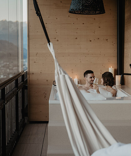 Blick auf das eingelassene Schaumbad, in dem ein Paar badet und romantische Momente geniesst.