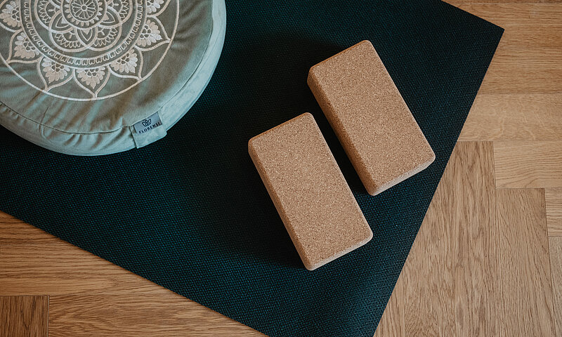 oga-Equipment mit Korkblöcken, Yogamatte und Meditationskissen im Hotel Berghof, ideal für Entspannung in St. Johann, Salzburg.