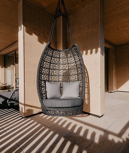 Stilvoller Hängekorb auf der Terrasse der Premium Familiensuite mit Bergblick und sonniger Ausrichtung.