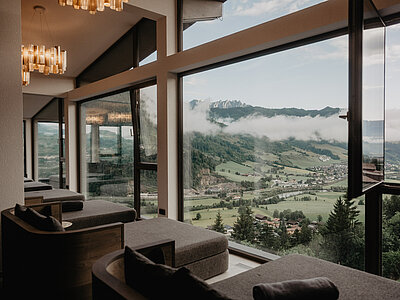 Ruheliegen mit Panoramafenstern und Ausblick auf die Berge im Wellnesshotel Berghof in Salzburg.