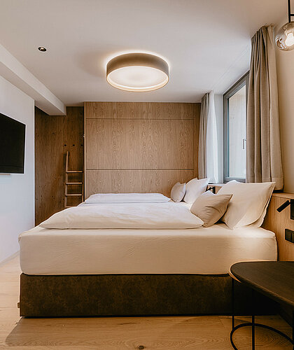 Helles Familienzimmer der Top Familiensuite mit zwei Einzelbetten, Zusatzbett und gemütlicher Atmosphäre im Hotel Berghof Salzburg.