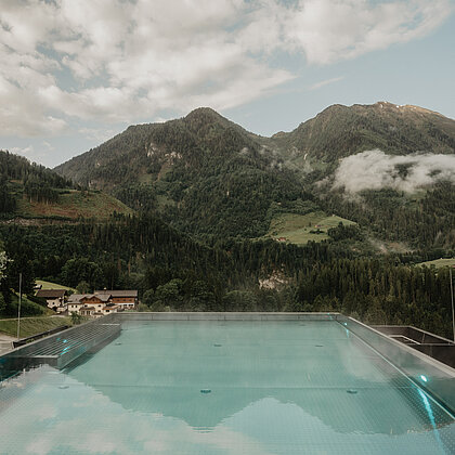Beheizter Infinitypool mit weiter Aussicht auf die Salzburger Alpen am Wellnesshotel Berghof.