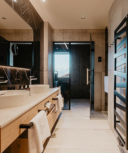 Badezimmer der Berghof Suite Premium mit Doppelwaschbecken, moderner Dusche und hochwertigen Materialien im Hotel Berghof Salzburg.