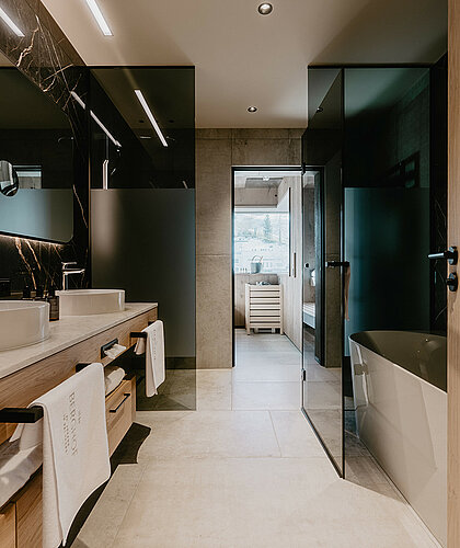 Luxuriöses Badezimmer der Premium Familiensuite mit moderner Sauna, Doppelwaschbecken und eleganter Einrichtung im Hotel Berghof.