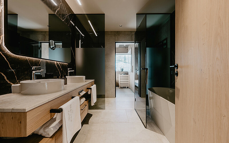 Luxuriöses Badezimmer der Premium Familiensuite mit moderner Sauna, Doppelwaschbecken und eleganter Einrichtung im Hotel Berghof.