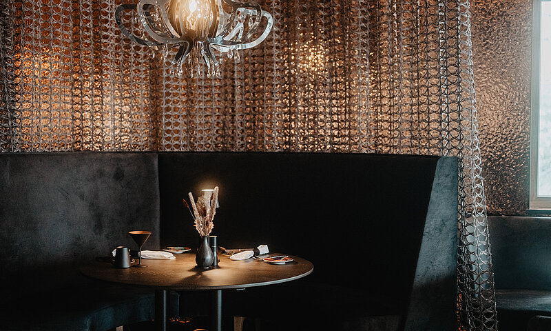 Essecke im Medusa, schwarze Bänke und eine Kupferwand.