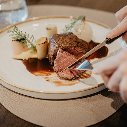 Zartes Rinderfilet mit Sauce, Gemüse und stilvoller Anrichtung im Hotel Berghof in St. Johann, Salzburg.