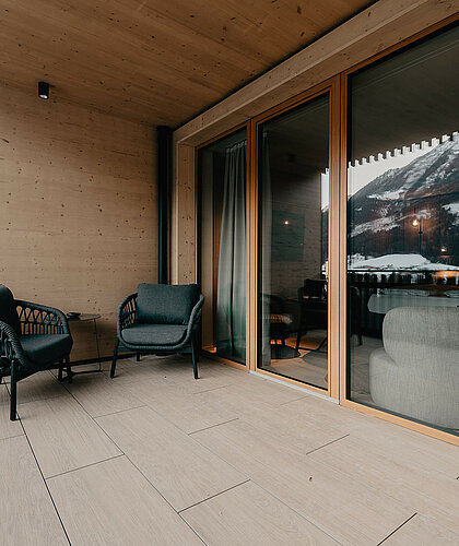 Privater Terrassenbereich der Junior Suite Premium mit gemütlichen Sitzmöbeln und freiem Ausblick auf die Berge von St. Johann.