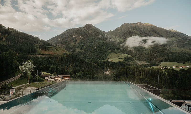 Beheizter Infinitypool mit weiter Aussicht auf die Salzburger Alpen am Wellnesshotel Berghof.