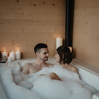 Paar genießt romantische Momente in der Outdoor Badewanne.